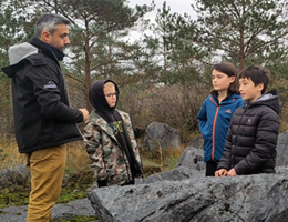 An adult speaking to 3 children